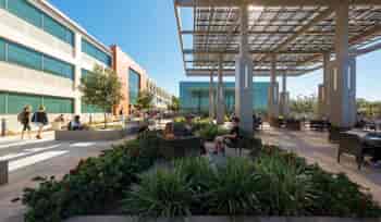 Solar canopy with Lumos Solar LSX Modules covering outdoor seating area with students sitting and talking and people walking by