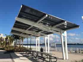 Solar Canopy Shade Structure provides shade and solar power for people at the picnic area in front of the water at the Manatee Viewing Center in Florida