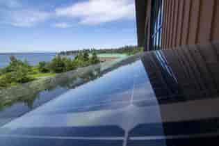 LSX Solar Panel Closeup with view of lake and trees in backgroundTulalip Gathering Hall with large wooden beams and view of lake and trees in background