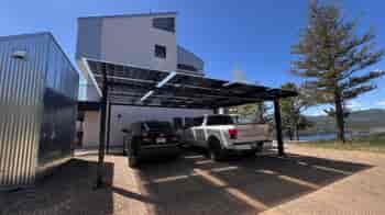 Free standing structure with solar panels providing shade to two vehicles.